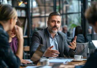 Fototapeta premium Professional Businessman Discussing Plans with Colleagues in Modern Office Cafe