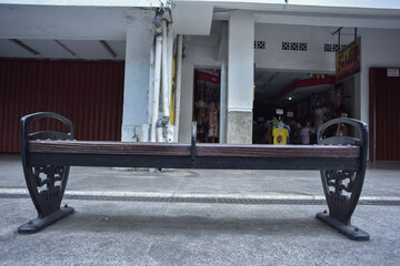 Outdoor wooden bench at road sidewalk low angle perspective shot