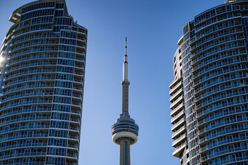 Naklejka premium View of the CN Tower among the skyscrapers. CN Tower from the Harbourfront neighborhood. Toronto, Canada - April 30, 2024.