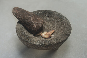 closeup of Stone mortar and pestle, stone bowl filled with garlic,rock mortar and pestle ,Cooking...