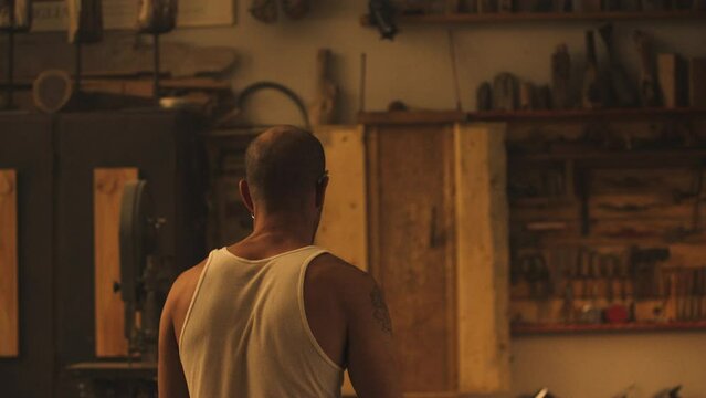 Man throwing knives at wooden wall