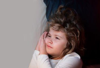 Portrait of little child lying on big bed. Concept of happy children having good night. Child...