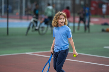 Cute kid playing the tennis on court.