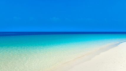 Nature of the beach and sea Summer with sunshine, sandy beaches, clear blue waters sparkling against the blue sky. On an island with good ecology and environment Background for summer vacation