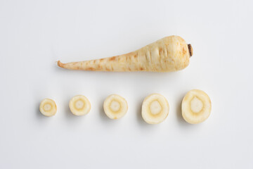Fresh parsnips including sliced ones isolated on a white background. Parsnip (Pastinaca sativa) is a root vegetable closely related to carrot and parsley, all belonging to the family Apiaceae.
