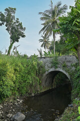 Fototapeta na wymiar Small concrete old bridge in countryside with blue sky background