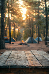 A blurred background of a camping area features tents and a campfire in a forest, with an empty wooden tabletop for product display montage.