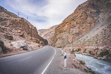 Road and river in a rocky gorge made of colored rocks in the Fan Mountains in Tajikistan