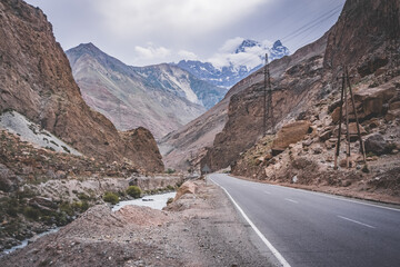 Road and river in a rocky gorge made of colored rocks in the Fan Mountains in Tajikistan