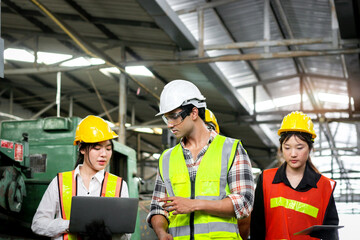 Group of industrial foreman engineer and workers with helmet and safety vest walking past to inspect machinery engine and production process at manufacturing industry factory. Teamwork at workplace
