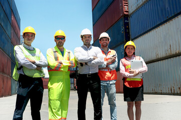 Group of worker team with helmet and safety vest stand in line with arms crossed at logistic...
