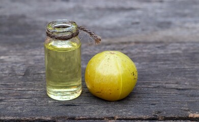 Indian Gooseberry Fruit or Amla Oil in a Glass Isolated on Wooden Background with Copy Space, Also Known as Emblica Myrobalan or Phyllanthus Emblica