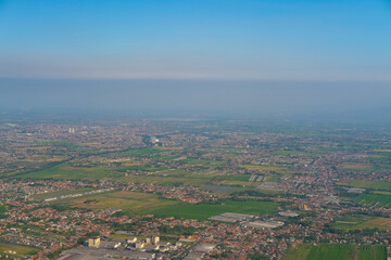 Aerial view of Sidoarjo near Juanda International Airport, showing urban and rural landscapes with a winding river, green fields, and a distant volcano partially covered by haze