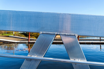 Detail of a section of a shiny metal rail on a dock at Tenmile Lake, Lakeside, Oregon, USA