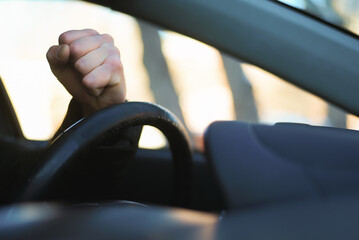 Angry driver is honking and is yelling by sitting of a steering wheel. Road aggression concept....