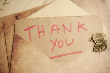 thank you message and envelope on wooden table