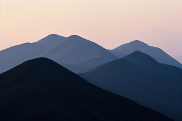 The elongated shadows of mountain ridges cast by the soft light of sunset