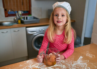 Young girl, baking and portrait in kitchen with flour on nose for growth, learning and development...