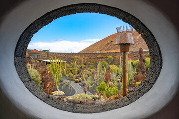 View through an oval window at the entrance to the  cactus garden Jardin de Cactus of Lanzarote
