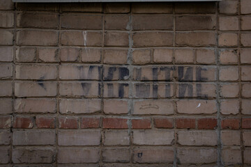 A brick wall with the inscription "Shelter" in Russian.
