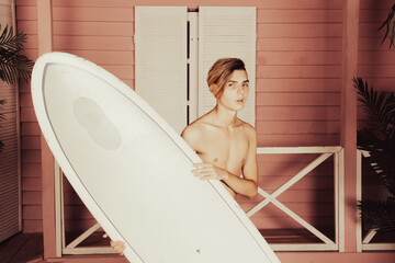 Early morning. A young attractive guy is relaxing near a bungalow.
