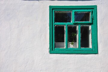 old window in the wall. green old wooden window on a white wall. country style