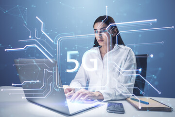 Attractive thoughtful young businesswoman using laptop at desk with creative square circuit button...