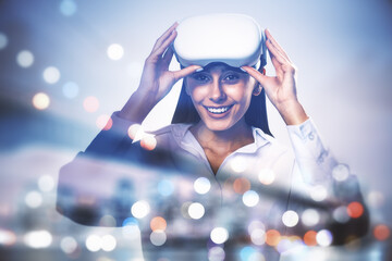 Attractive happy young european businesswoman with VR glasses standing on blurry airy city...
