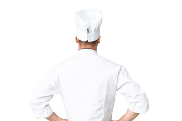 Young caucasian chef over isolated chroma key background in back position