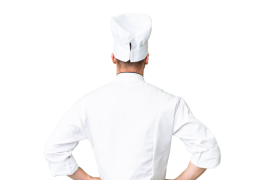 Young caucasian chef over isolated chroma key background in back position
