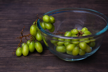 Comida. Uvas verdes en tazon de cristal, a medio salir, palno detalle.