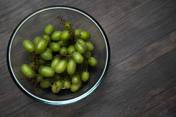 Comida. Uvas verdes en tazon de cristal, plano cenital.