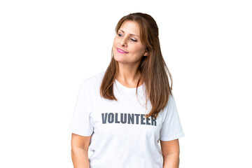 Middle age volunteer woman over isolated background looking to the side and smiling