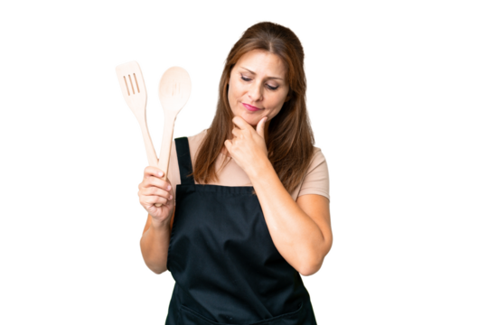 Middle age caucasian woman holding a rolling pin over isolated background looking to the side and smiling