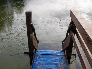 Swimming pool hand-rails and ladder leading into freezing pond, Finland