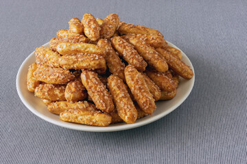 Delicious crunchy sugar and cinnamon cookies on a plate and fabric gray tablecloth