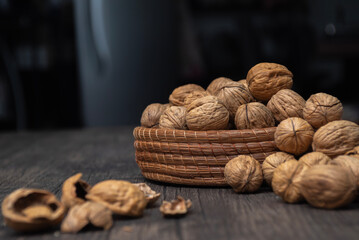 Comida. Canasta llena de nueces tanto que se desbordan, con cascaras rotas sobre la mesa.