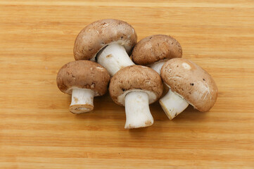 Fresh champignon mushroom isolated on wooden background