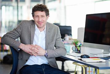 Man, desk and computer with smile in portrait in office with designer for creative project. Male...