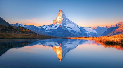 The breathtaking sunrise view of the iconic Matterhorn peak with its reflection in the still waters of a serene mountain lake