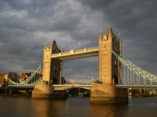 Obraz premium Tower Bridge in the evening light, backdrop clouds, highlighted in the sunlight - inspiring. 