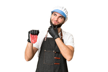 Butcher man wearing an apron and serving fresh cut meat over isolated chroma key background and looking up