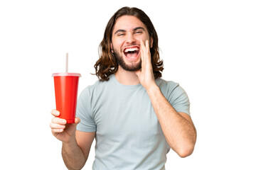 Young handsome man holding soda over isolated chroma key background shouting with mouth wide open