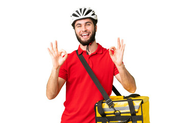 Young delivery man with thermal backpack over isolated chroma key background showing an ok sign with fingers