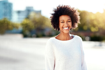 Portrait, woman and smile in street, outdoor and afro in urban, fashion and natural hair. Winter...