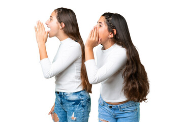 Friends girls holding gift and a birthday cake over isolated chroma key background shouting with mouth wide open to the lateral