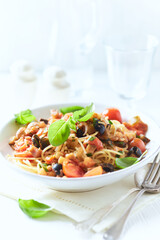 Spaghetti Pasta with Vegetables and fresh Basil on bright wooden Background.