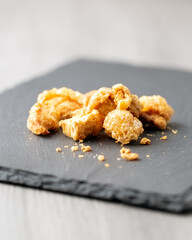 Snack of salted pork rind scratchings on slate 