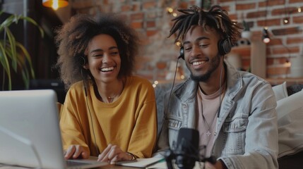 Happy male and female influencers smiling while recording a podcast together in a studio