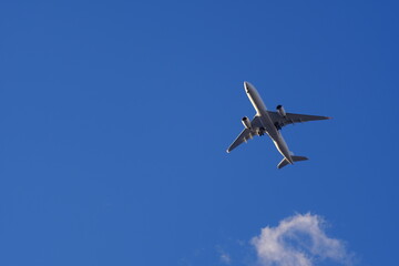 青空を飛ぶ飛行機と雲
